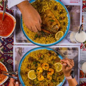A delicious top view of traditional Middle Eastern Kabsa and Mandi rice dishes served with rich flavors.